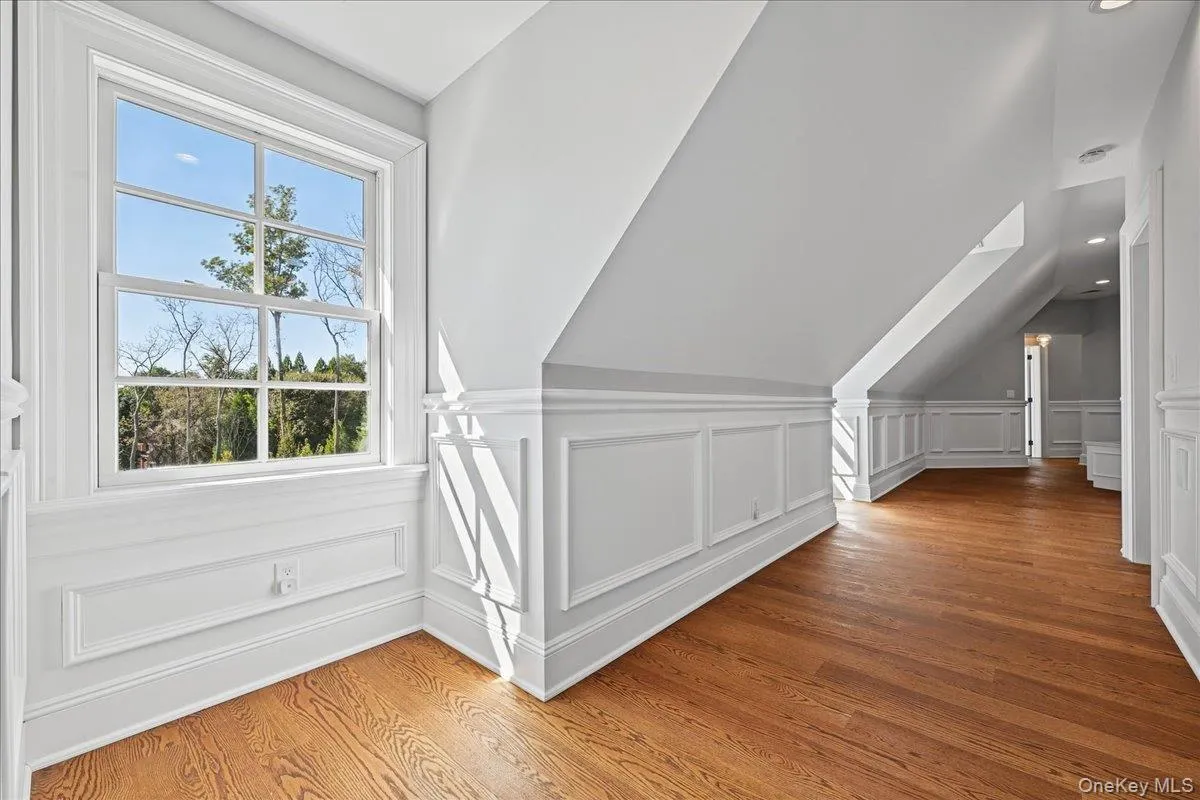 Hardwood flooring, white wall paneling, double-hung window, white trim, recessed lighting Hardwood flooring, white wall paneling, double-hung window, white trim, recessed lighting