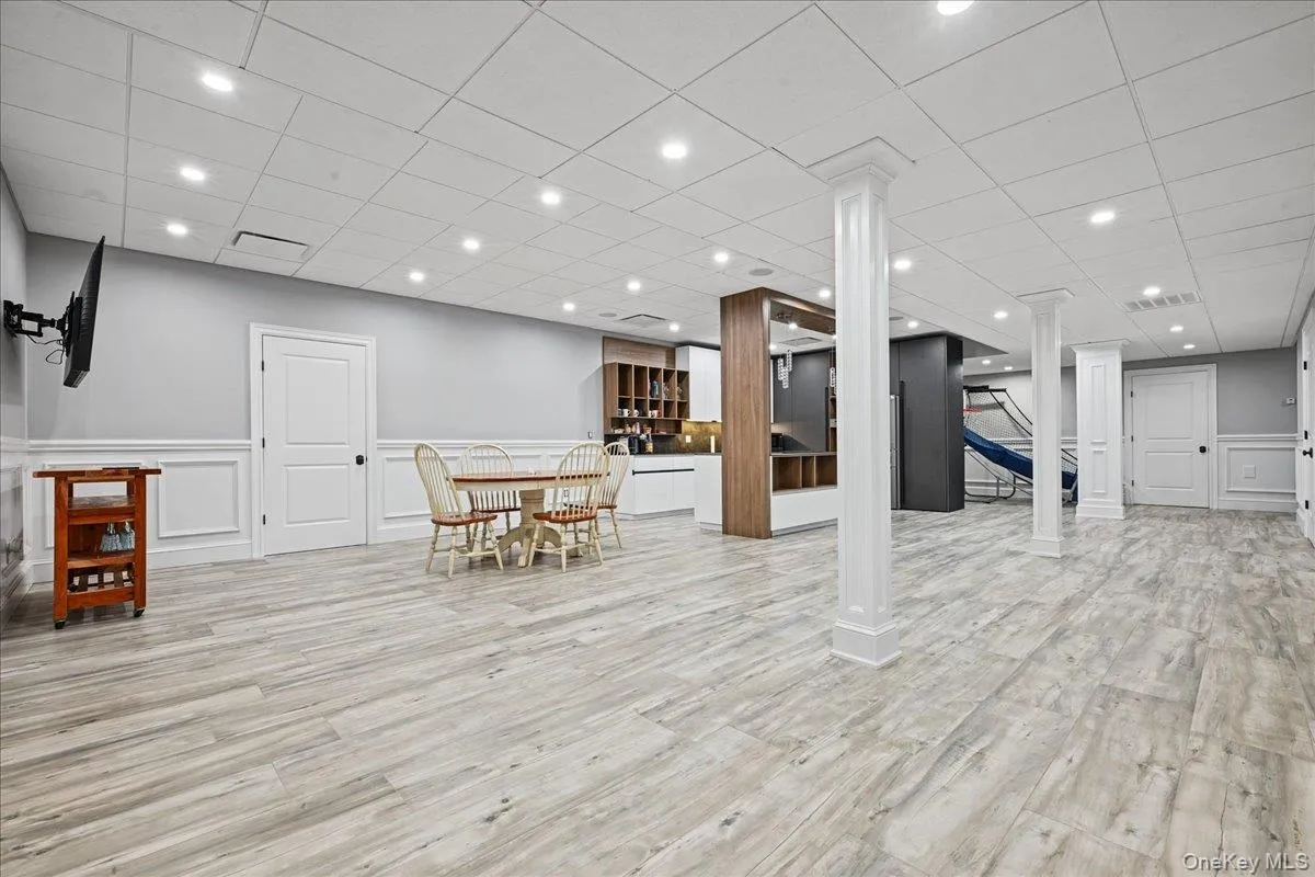 Recessed lighting illuminates the wood-finish flooring, wainscoting, and white trim Recessed lighting illuminates the wood-finish flooring, wainscoting, and white trim