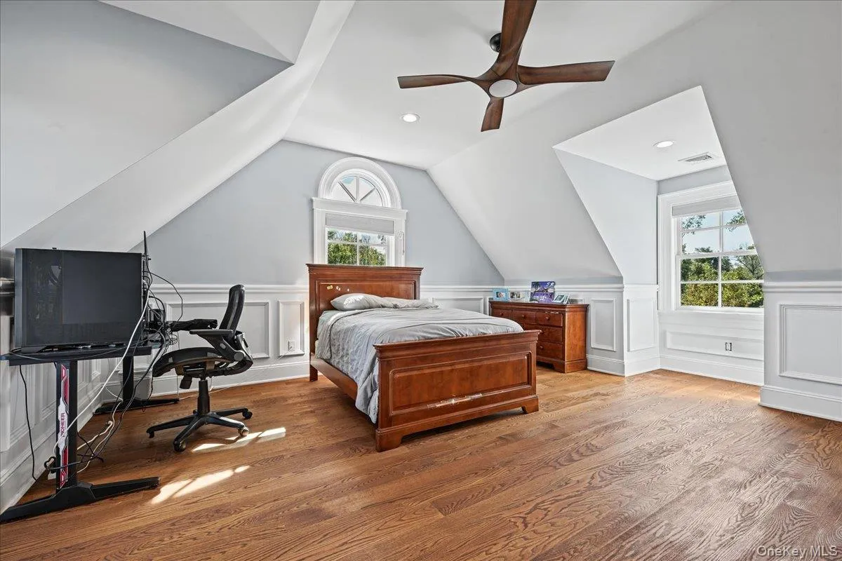 Hardwood flooring, two windows with white trim, recessed lighting, ceiling fan, and wainscoting details Hardwood flooring, two windows with white trim, recessed lighting, ceiling fan, and wainscoting details