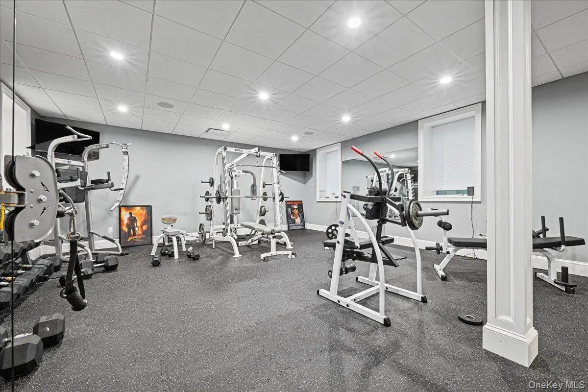 Dedicated fitness room featuring recessed lighting, a drop ceiling, and durable rubber flooring Dedicated fitness room featuring recessed lighting, a drop ceiling, and durable rubber flooring