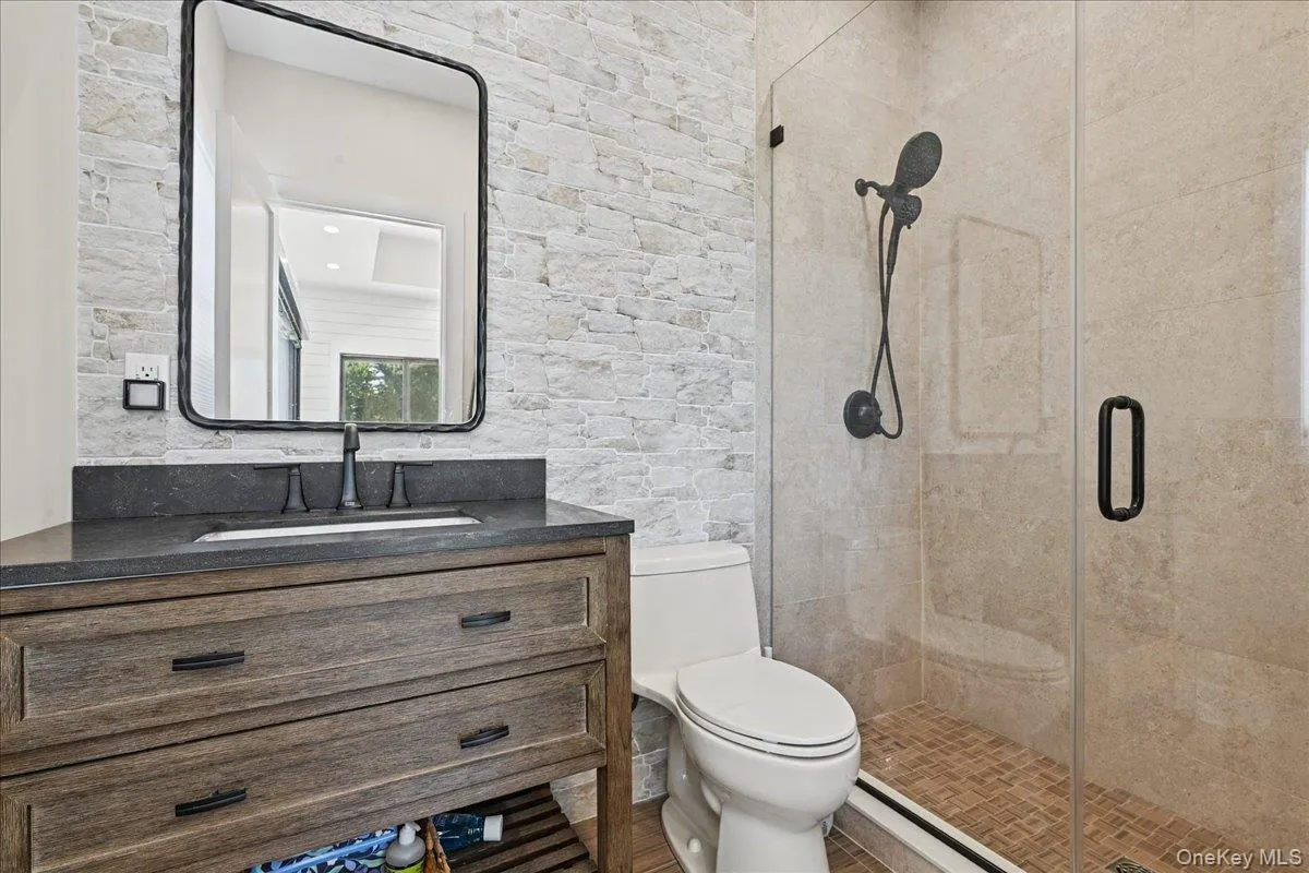 Wood-finish vanity with dark countertop and undermount sink - pool house Wood-finish vanity with dark countertop and undermount sink - pool house