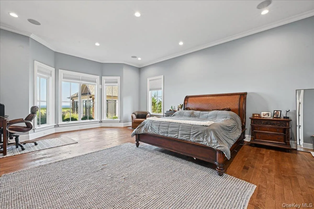 Hardwood flooring, recessed lighting, crown molding, bay window, and light gray wall paint Hardwood flooring, recessed lighting, crown molding, bay window, and light gray wall paint