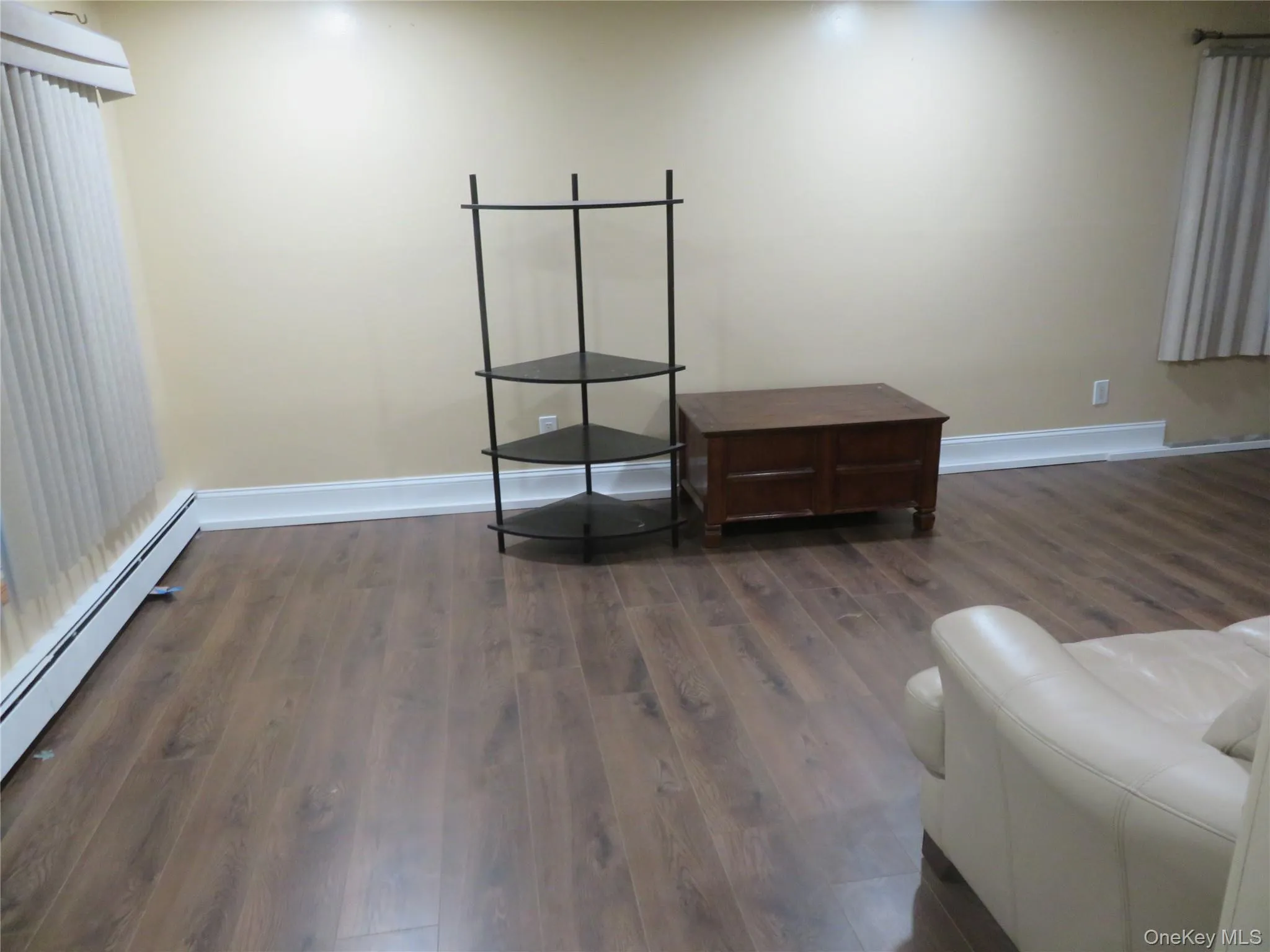Wood-finish flooring with white baseboards, cream-colored walls, and recessed lighting Wood-finish flooring with white baseboards, cream-colored walls, and recessed lighting