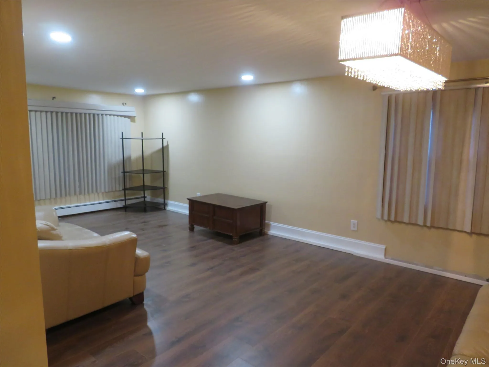 Recessed ceiling lighting, wood-finish flooring, and a decorative chandelier Recessed ceiling lighting, wood-finish flooring, and a decorative chandelier