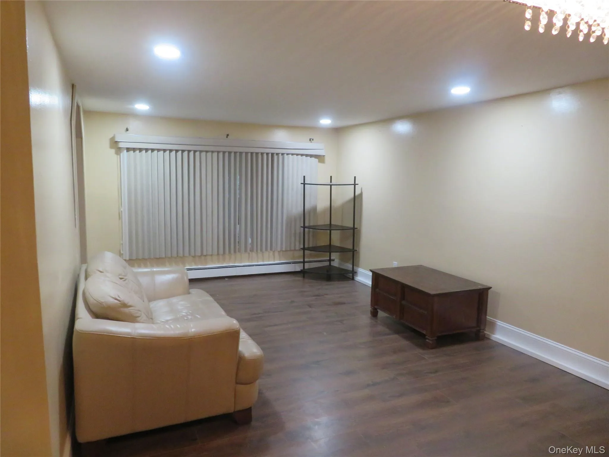 Recessed lighting, wood-finish flooring, vertical blinds, and a built-in baseboard heater Recessed lighting, wood-finish flooring, vertical blinds, and a built-in baseboard heater