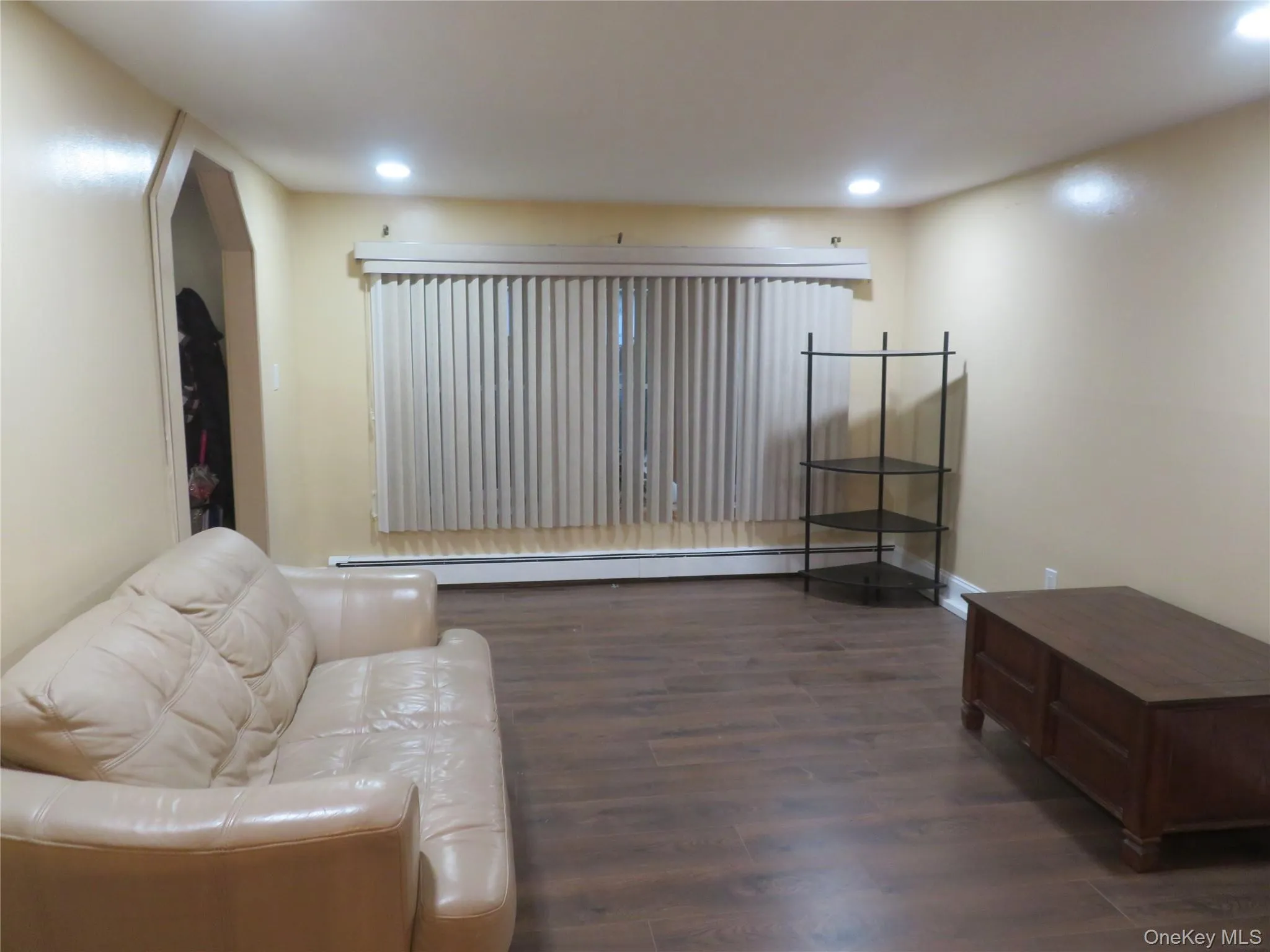 Recessed ceiling lighting, wood-finish flooring, and a large window with vertical blinds Recessed ceiling lighting, wood-finish flooring, and a large window with vertical blinds