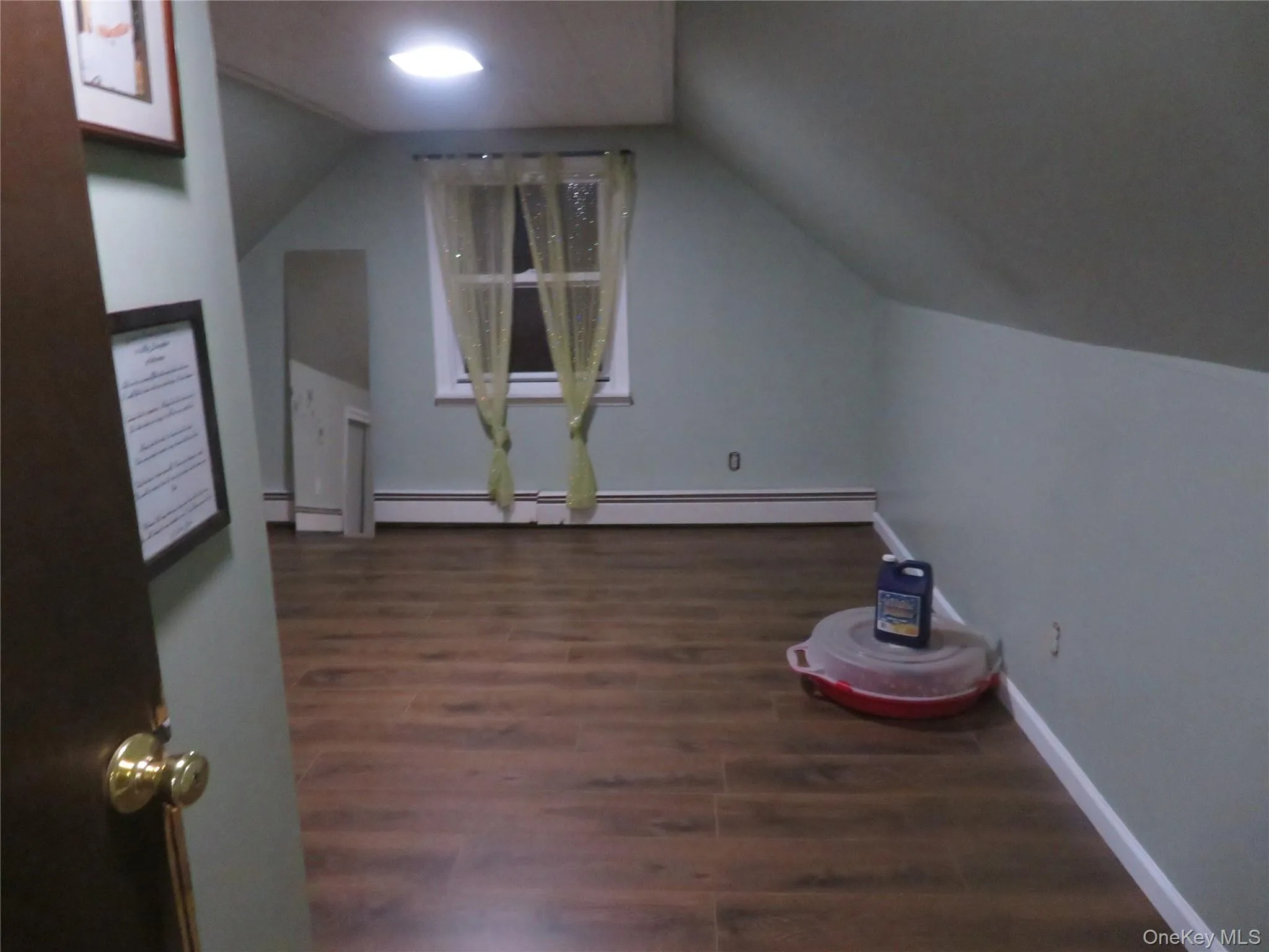 Green Room featuring sloped ceilings, wood-finish flooring, and a single window Green Room featuring sloped ceilings, wood-finish flooring, and a single window