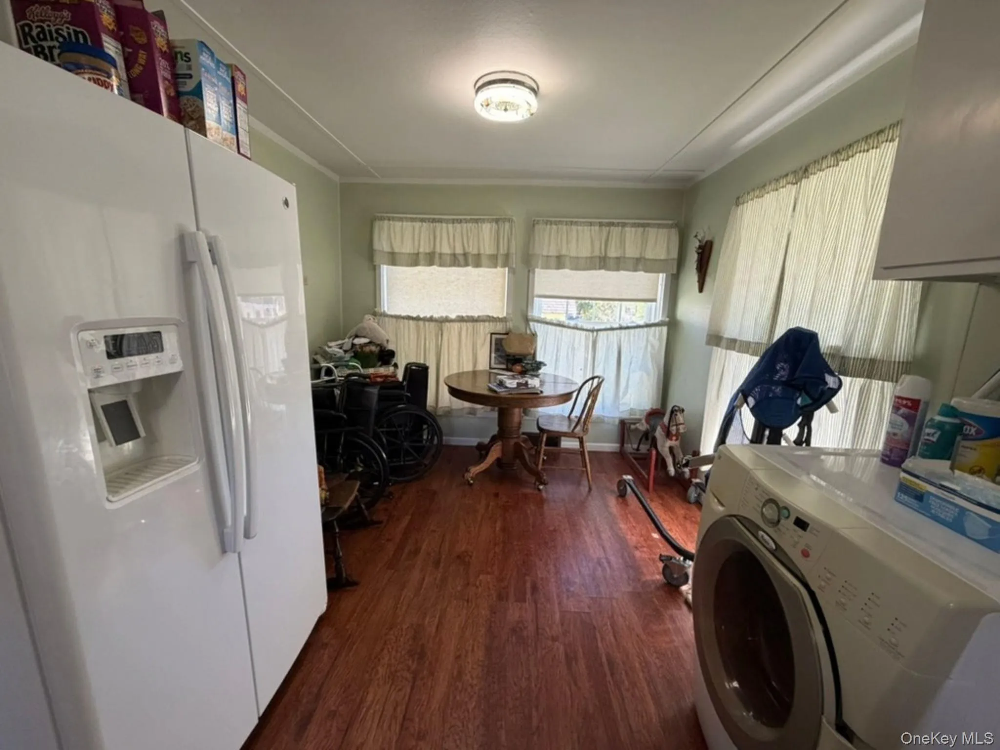 Laminate flooring with multiple windows and a ceiling-mounted light fixture Laminate flooring with multiple windows and a ceiling-mounted light fixture
