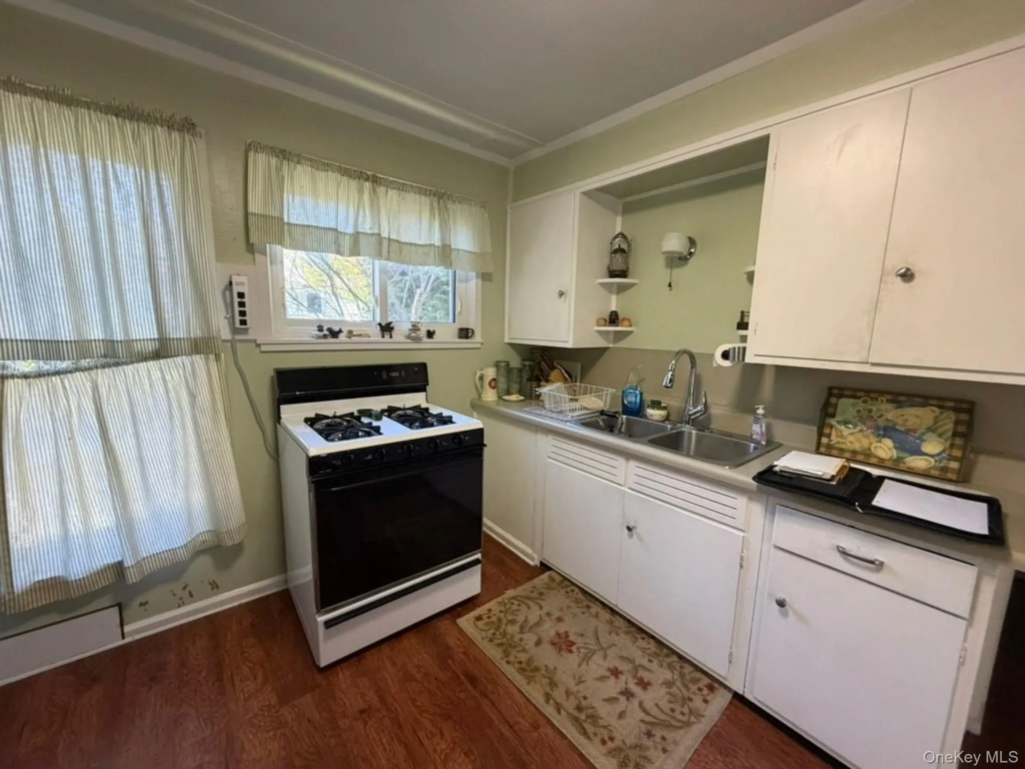 Laminate, dual-basin stainless steel sink, and white cabinetry Laminate, dual-basin stainless steel sink, and white cabinetry