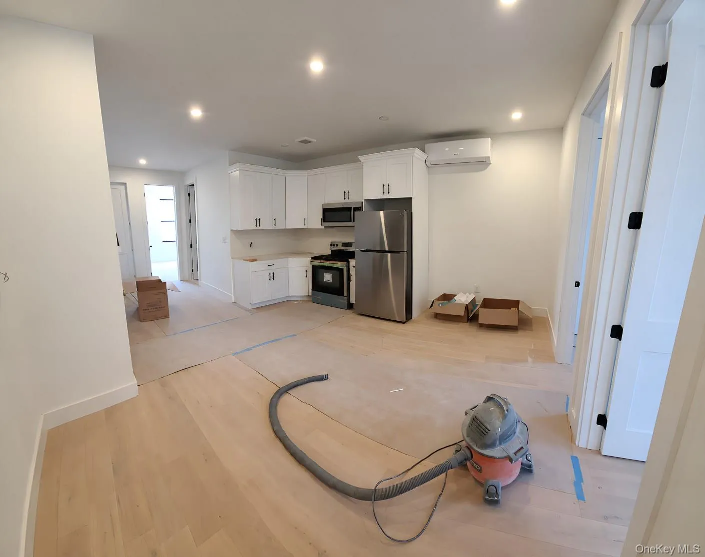 Recessed lighting illuminates the space, featuring wood-finish flooring and white walls Recessed lighting illuminates the space, featuring wood-finish flooring and white walls