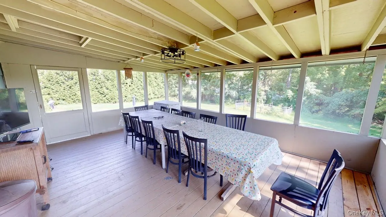 Enclosed porch adjacent to the kitchen for additional dining. Enclosed porch adjacent to the kitchen for additional dining.