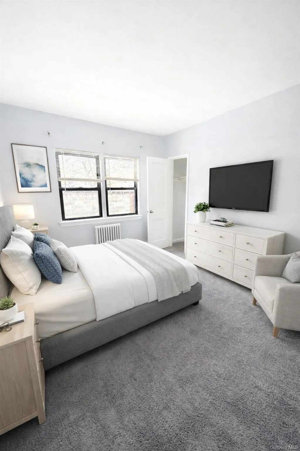 Carpeted bedroom featuring radiator and a spacious closet Carpeted bedroom featuring radiator and a spacious closet