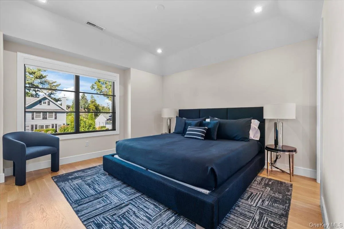 Hardwood flooring, recessed lighting, and a large window with dark trim Hardwood flooring, recessed lighting, and a large window with dark trim