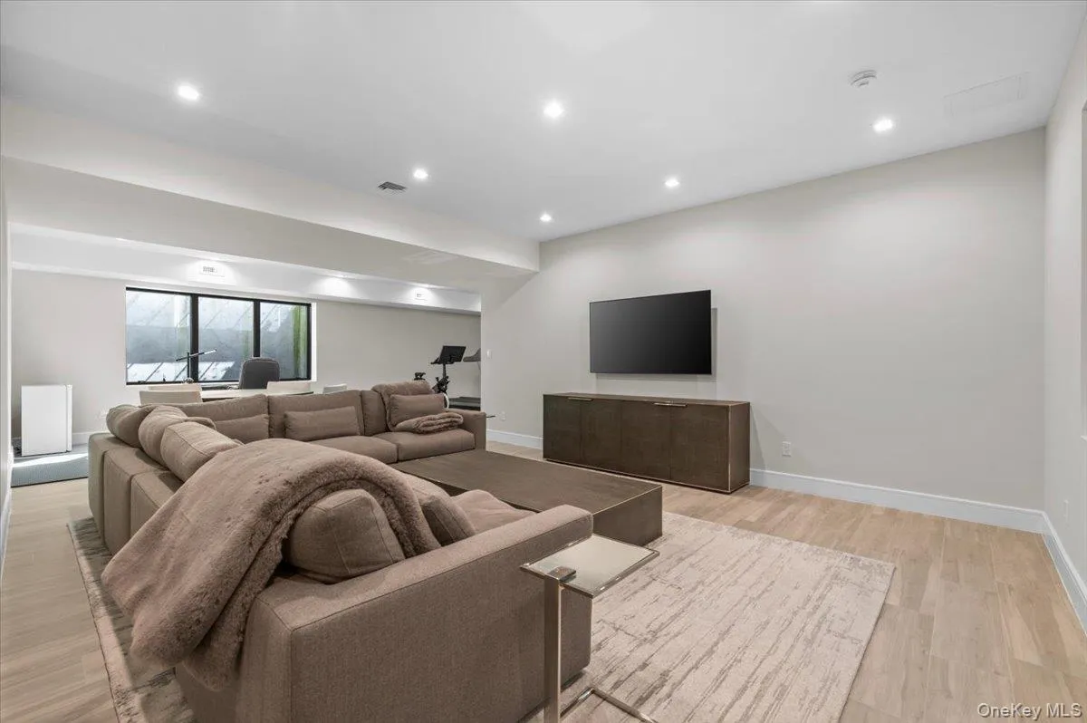 Recessed lighting, light wood-finish flooring, built-in media console, large windows, and a dedicated fitness area Recessed lighting, light wood-finish flooring, built-in media console, large windows, and a dedicated fitness area