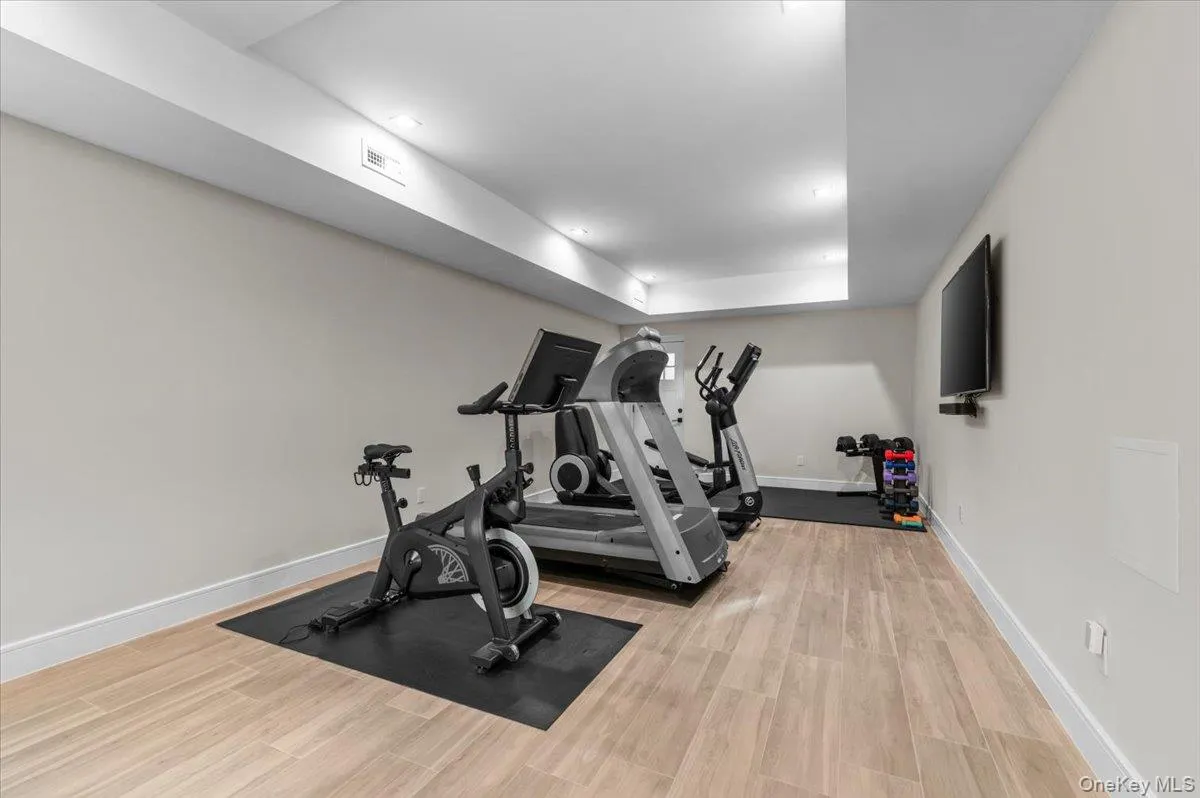 Recessed lighting, wood-finish flooring, and a mounted television Recessed lighting, wood-finish flooring, and a mounted television