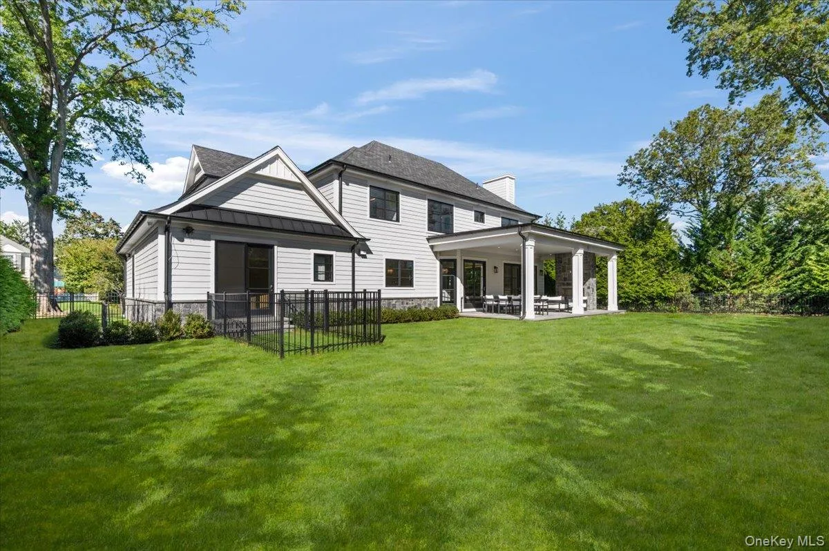 Expansive grass lawn with a covered patio featuring stone columns and Dog Pen Expansive grass lawn with a covered patio featuring stone columns and Dog Pen
