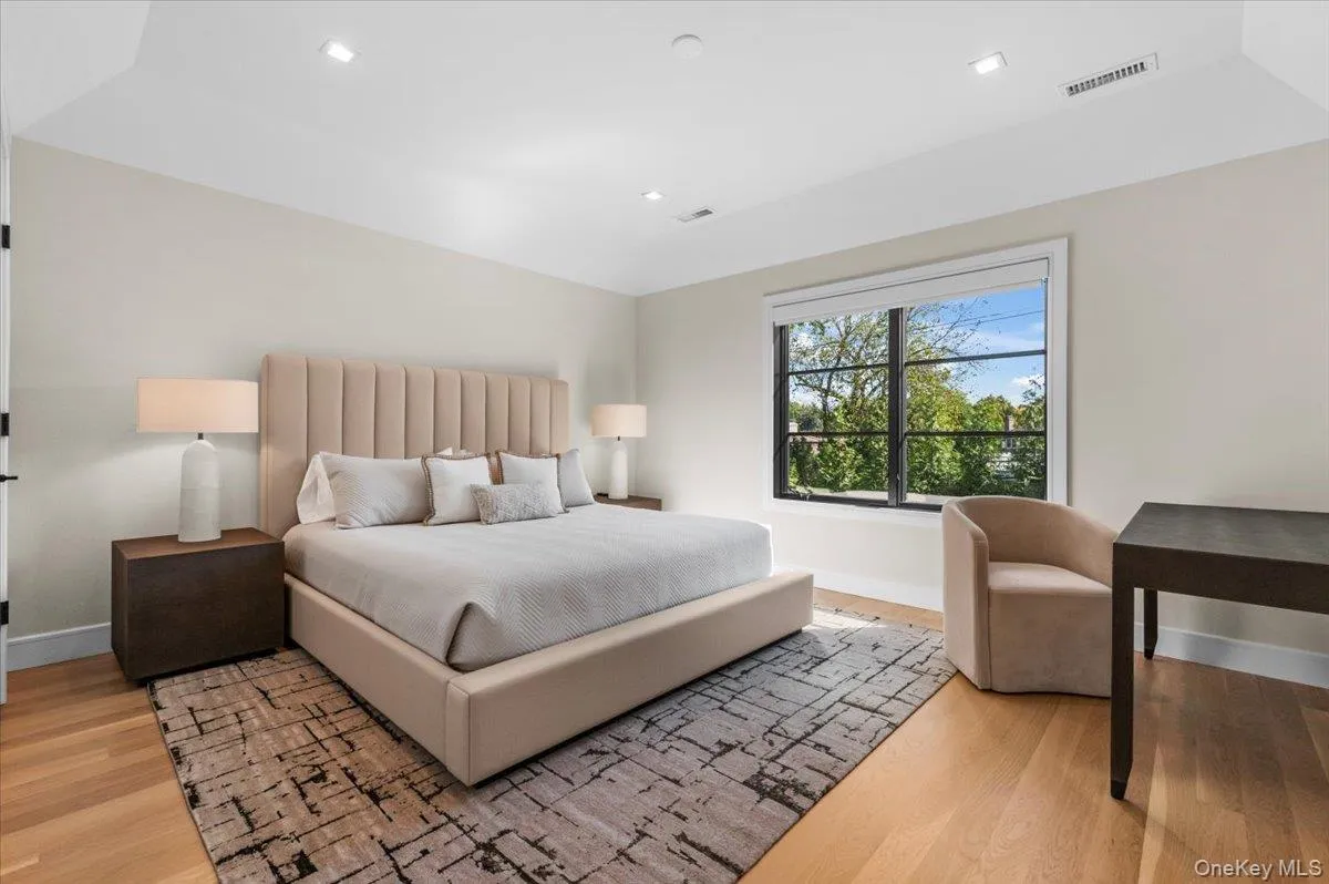 Hardwood flooring, recessed lighting, and a window with dark framing Hardwood flooring, recessed lighting, and a window with dark framing