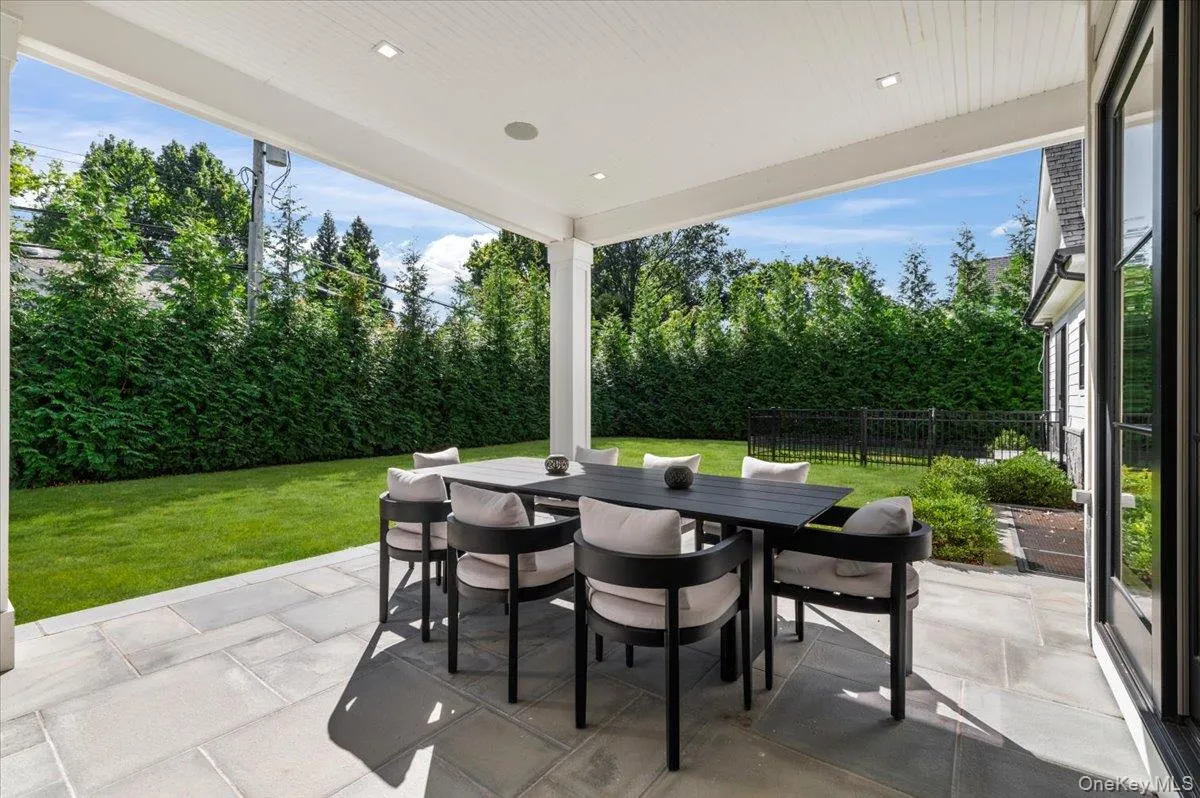 Covered outdoor patio with recessed lighting, large format pavers, and a manicured lawn Covered outdoor patio with recessed lighting, large format pavers, and a manicured lawn