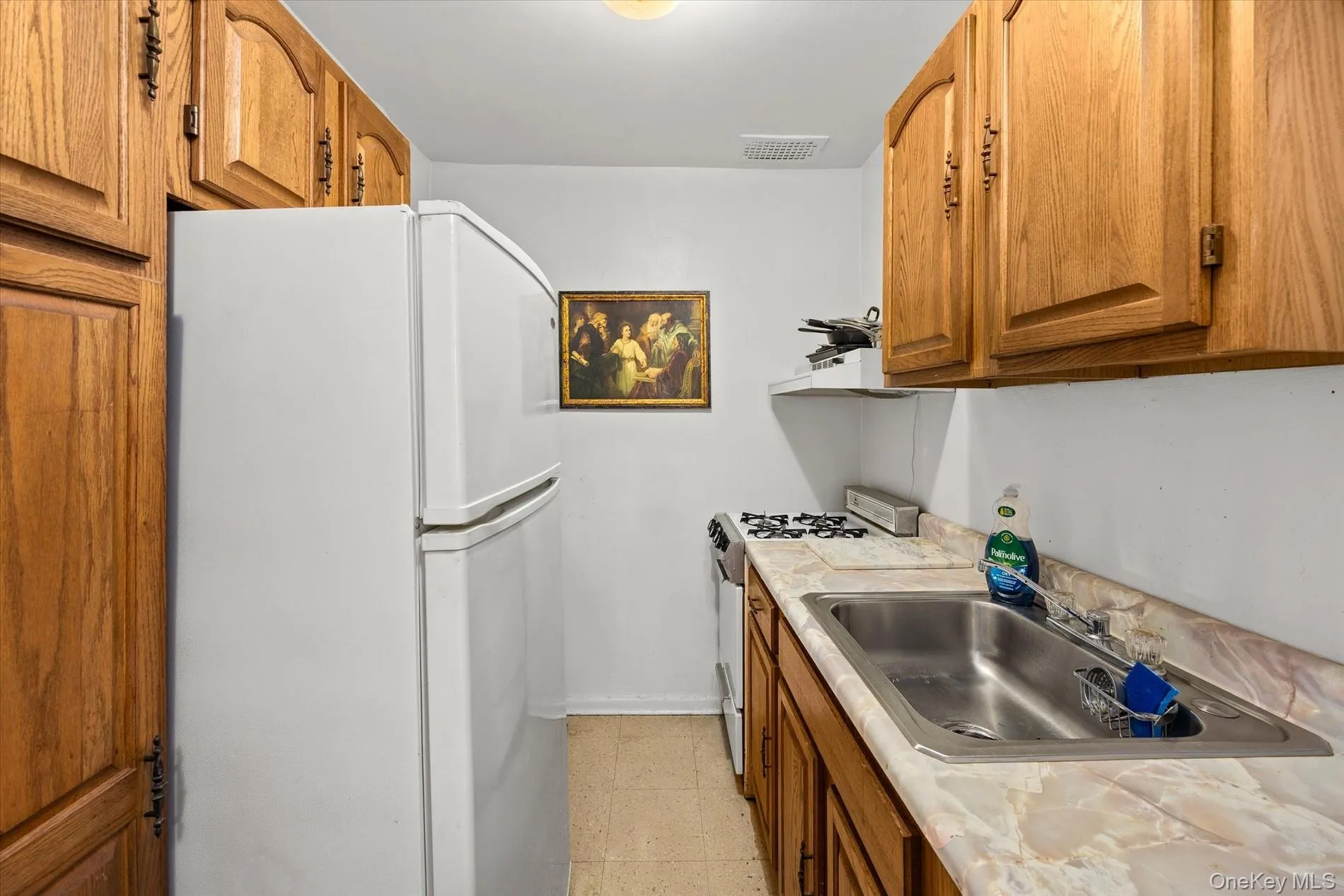 Kitchen featuring wood cabinetry, a stainless steel sink, a compact range, and a full-size refrigerator Kitchen featuring wood cabinetry, a stainless steel sink, a compact range, and a full-size refrigerator