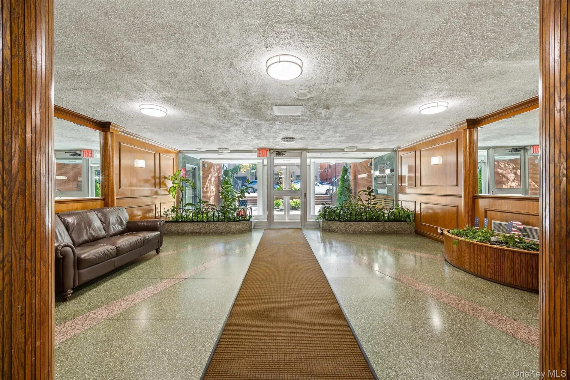 Terrazzo flooring with contrasting inlays, wood paneling, built-in planters with greenery, and recessed lighting Terrazzo flooring with contrasting inlays, wood paneling, built-in planters with greenery, and recessed lighting