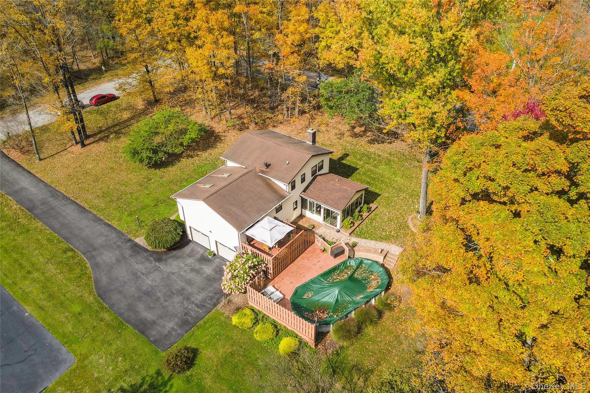 Expansive backyard with a manicured lawn and mature trees, above ground pool and featuring a multi-level wood deck and a stone chimney Expansive backyard with a manicured lawn and mature trees, above ground pool and featuring a multi-level wood deck and a stone chimney