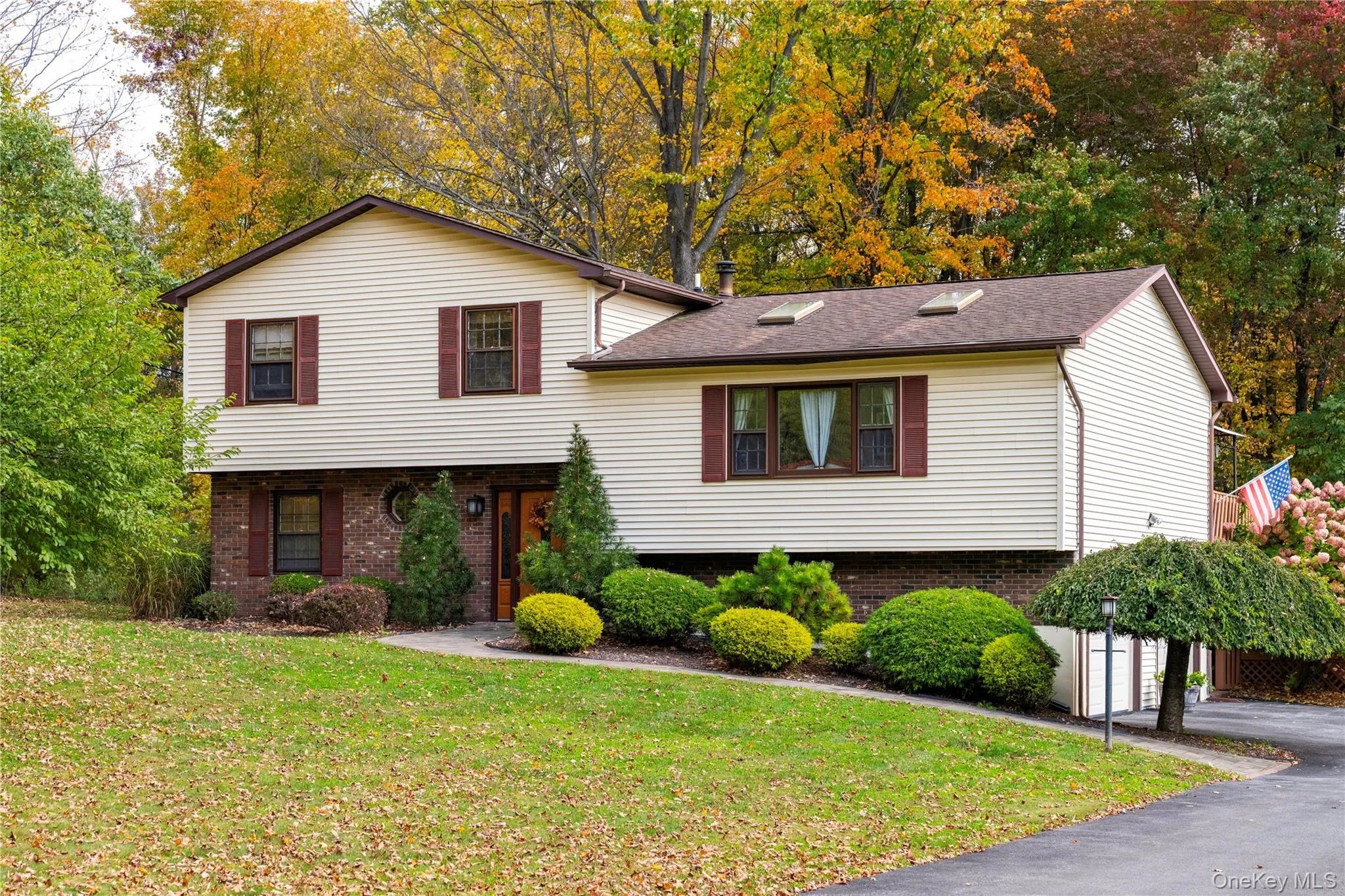 Home surrounded by mature trees and landscaping, featuring a paved driveway and an expansive front lawn Home surrounded by mature trees and landscaping, featuring a paved driveway and an expansive front lawn