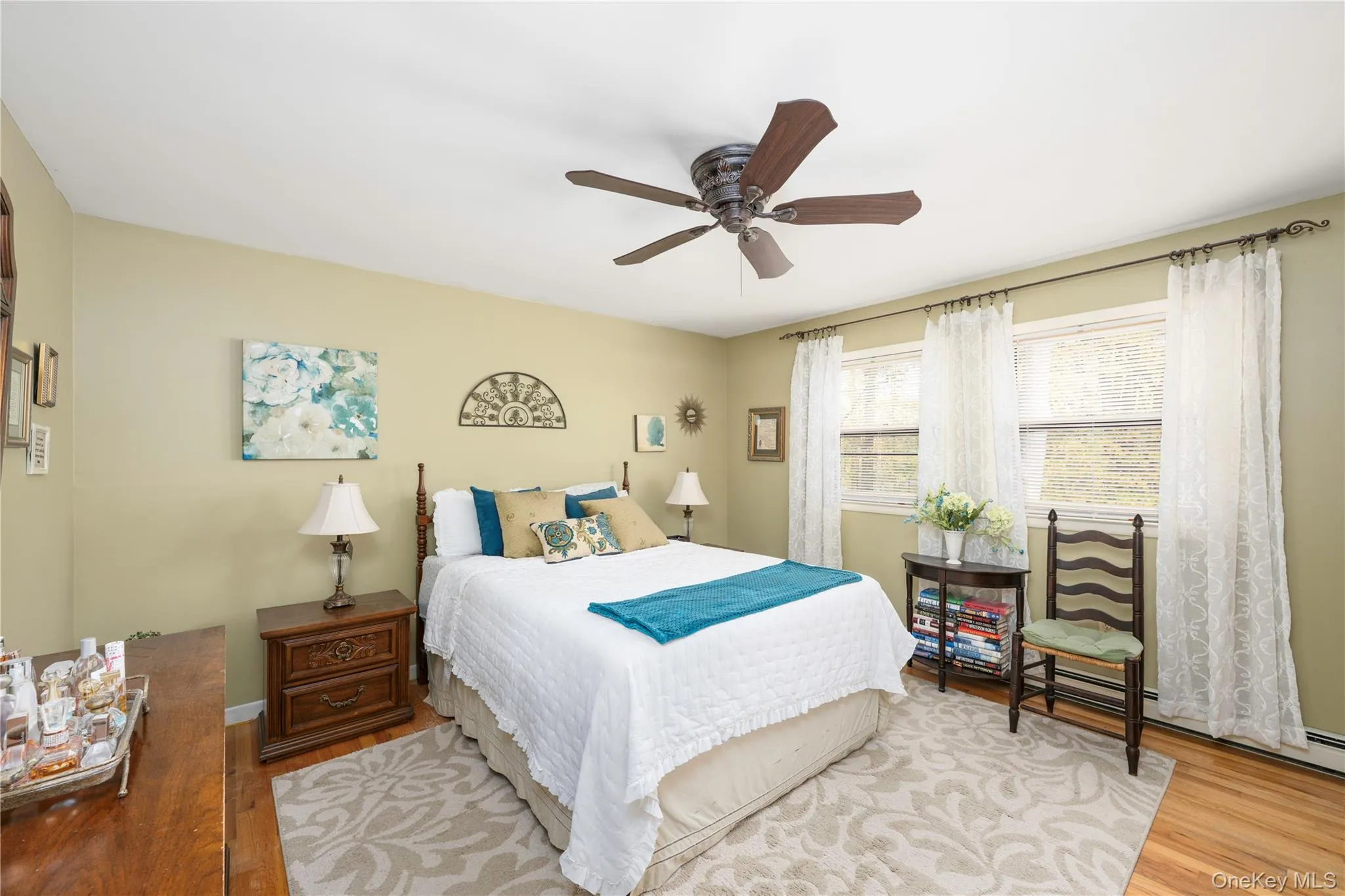 Bedroom featuring hardwood flooring, multi-pane windows, and a ceiling fan Bedroom featuring hardwood flooring, multi-pane windows, and a ceiling fan