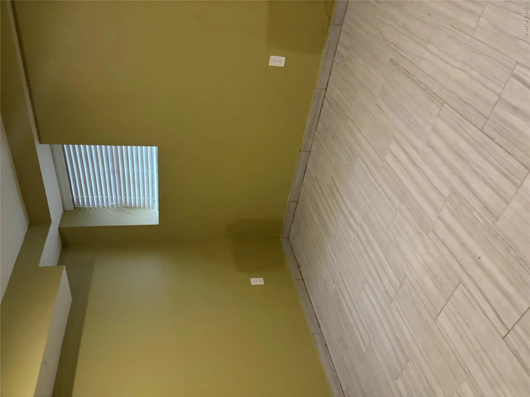 Recessed window with horizontal blinds, neutral wall finish, and large format tiled flooring Recessed window with horizontal blinds, neutral wall finish, and large format tiled flooring