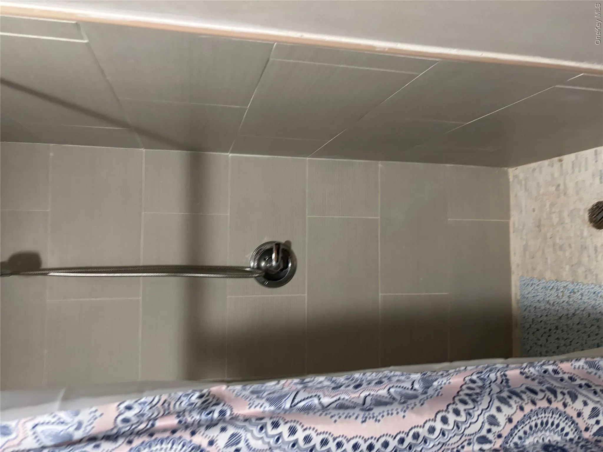 Tile shower with a brushed metal shower fixture Tile shower with a brushed metal shower fixture