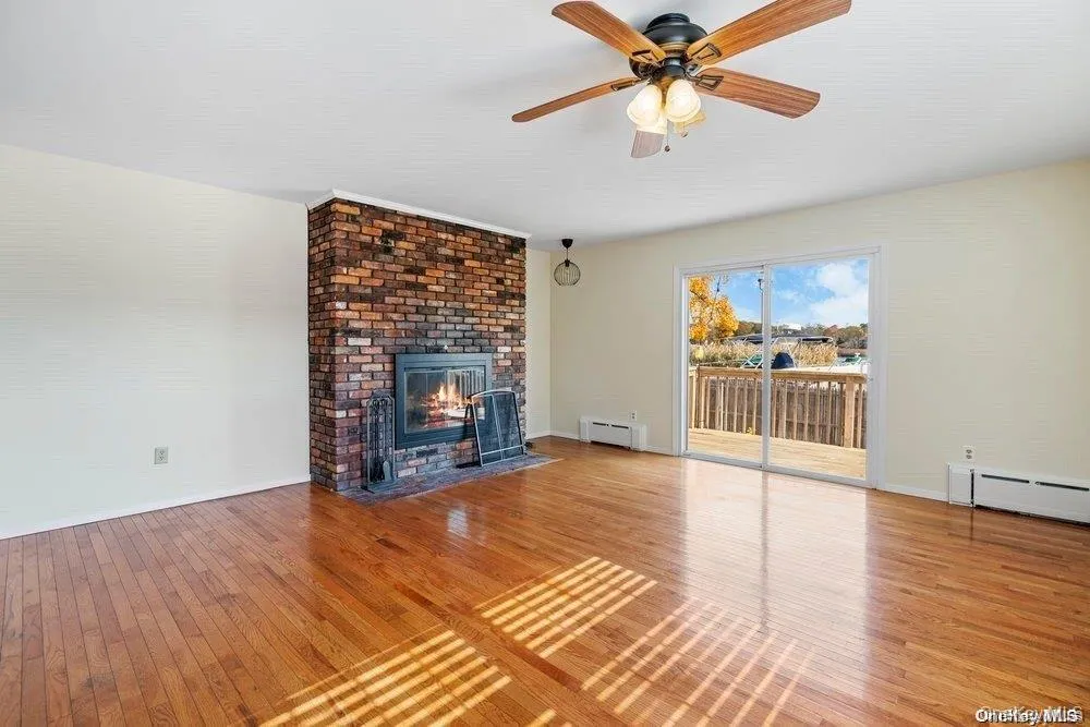Spacious Family Room with Fireplace and Sliding Glass doors leading out to water view deck and yard Spacious Family Room with Fireplace and Sliding Glass doors leading out to water view deck and yard