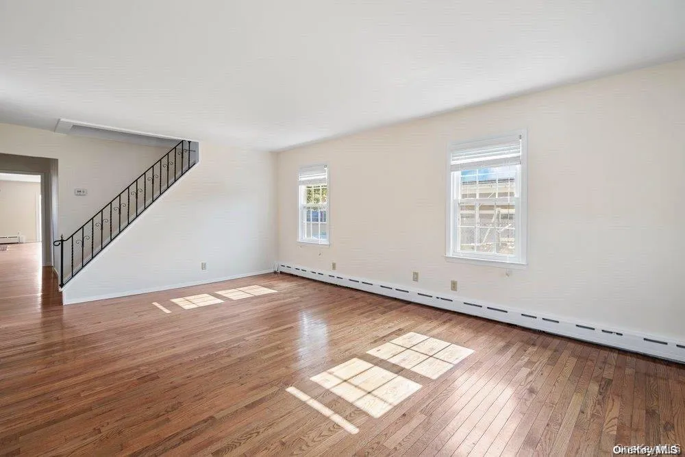 Sunny living room with hardwood floors, stairs lead to loft. Sunny living room with hardwood floors, stairs lead to loft.