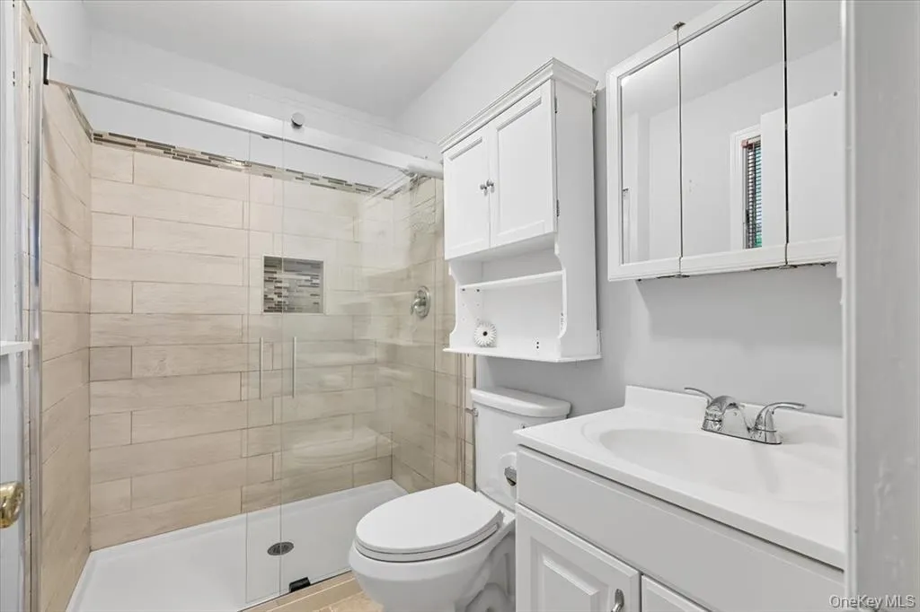 Bathroom featuring a shower stall and vanity Bathroom featuring a shower stall and vanity