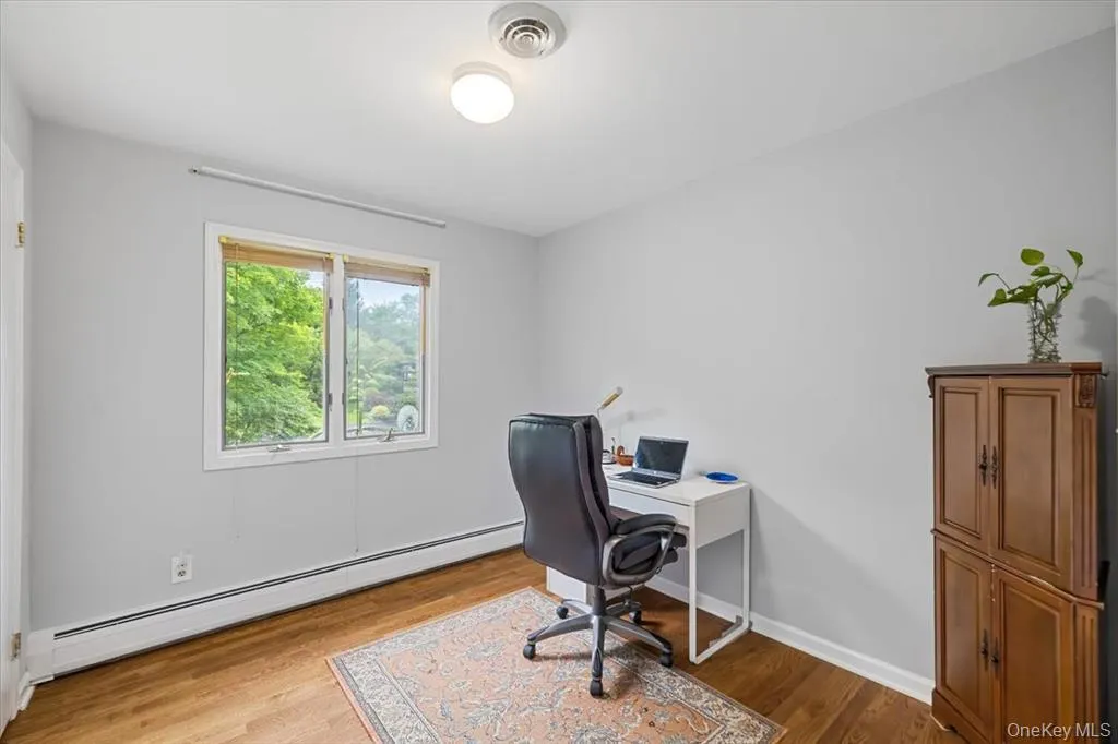 Office space with a baseboard heating unit and light wood-type flooring Office space with a baseboard heating unit and light wood-type flooring