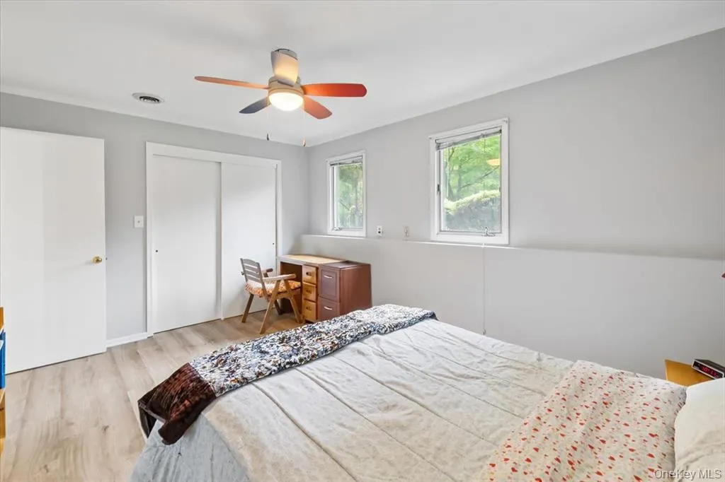 Bedroom featuring light wood-style floors, a closet, ceiling fan, and ornamental molding Bedroom featuring light wood-style floors, a closet, ceiling fan, and ornamental molding
