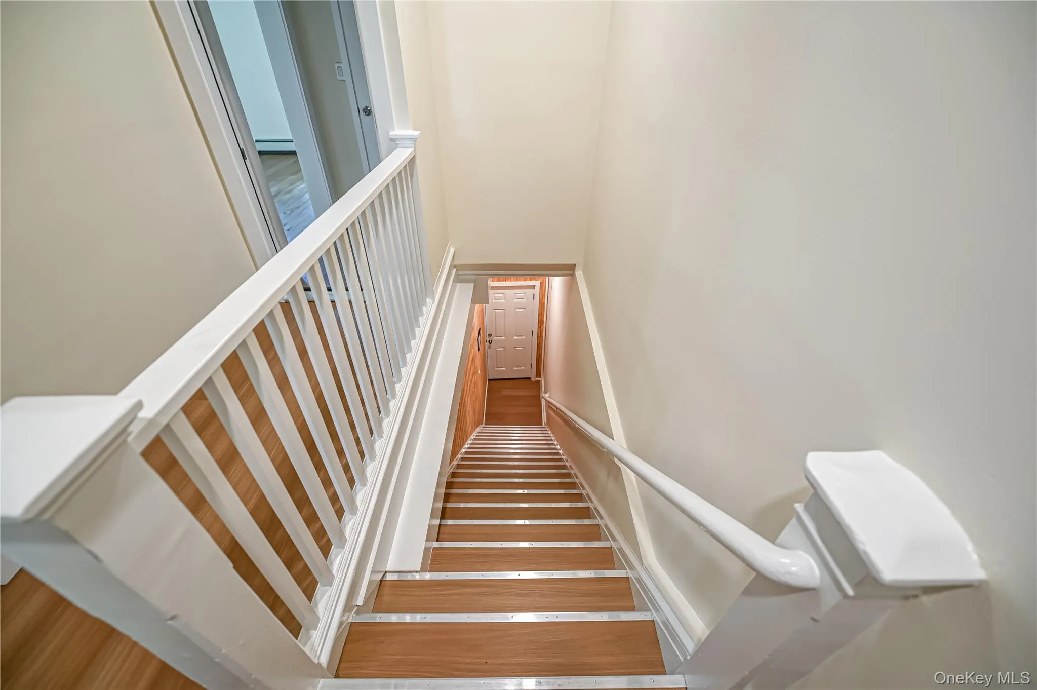 Staircase featuring wood finished floors Staircase featuring wood finished floors