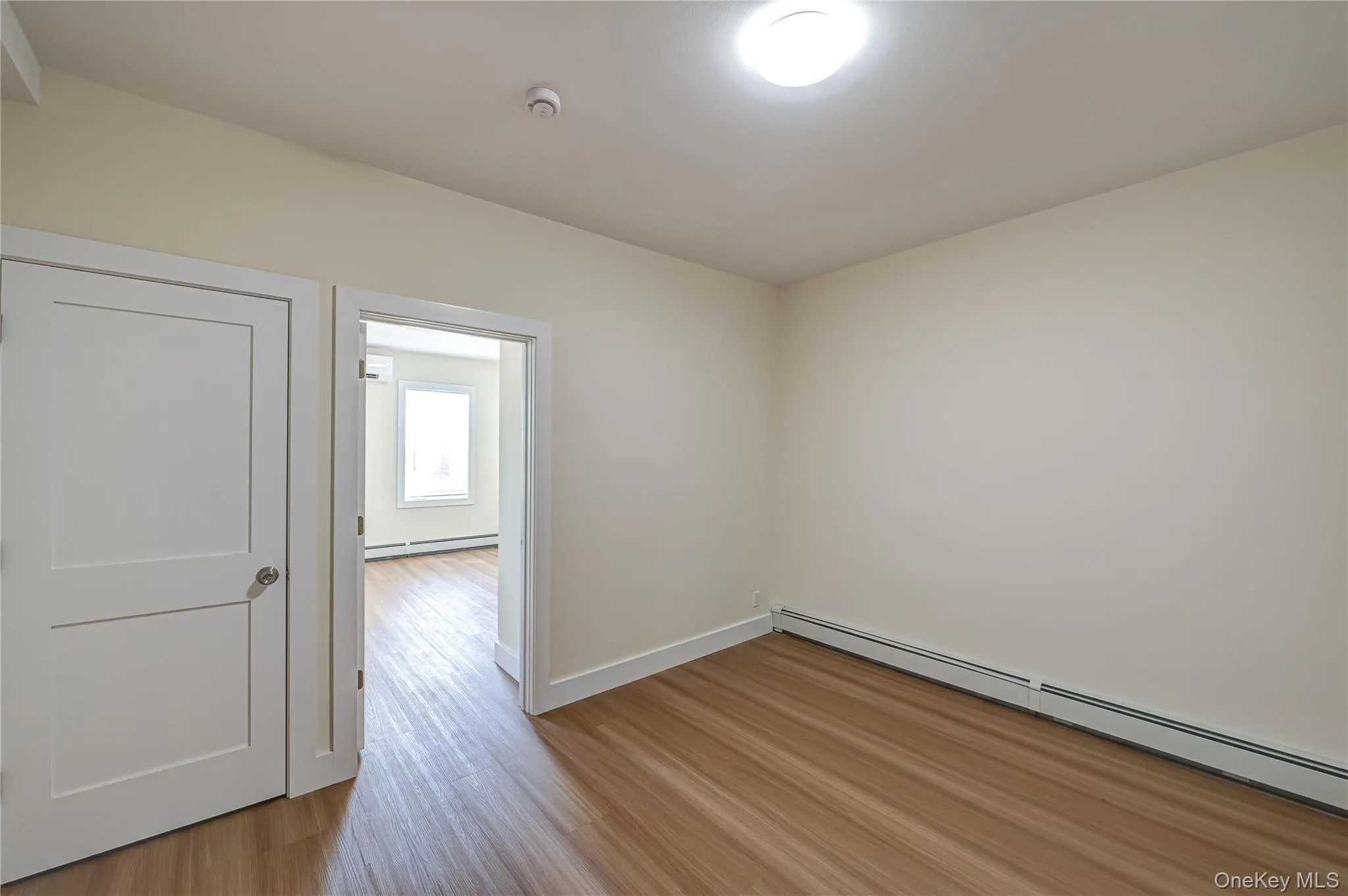 Spare room featuring light wood-style flooring and a baseboard radiator Spare room featuring light wood-style flooring and a baseboard radiator