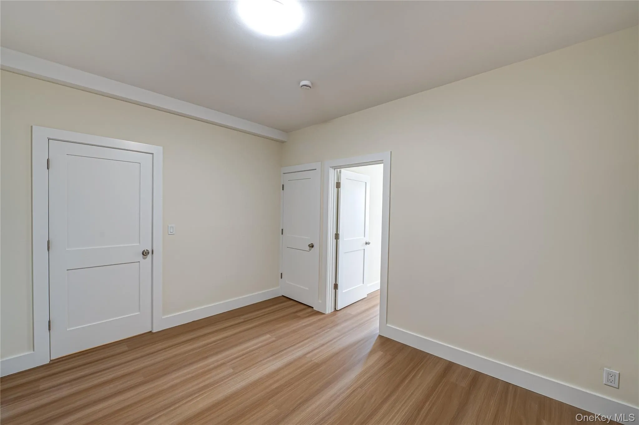 Unfurnished room with light wood-style flooring and baseboards Unfurnished room with light wood-style flooring and baseboards