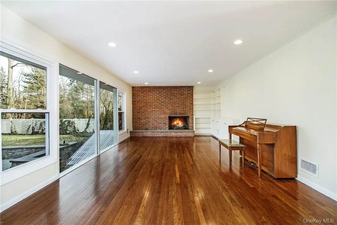 View of great room with large windows looking over yard and fireplace. Photos taken when house was empty prior to occupancy. View of great room with large windows looking over yard and fireplace. Photos taken when house was empty prior to occupancy.