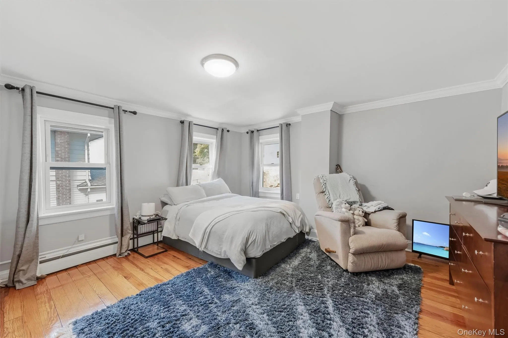 Spacious bedroom filled with natural light, featuring gleaming hardwood floors and a peaceful, inviting atmosphere. Spacious bedroom filled with natural light, featuring gleaming hardwood floors and a peaceful, inviting atmosphere.