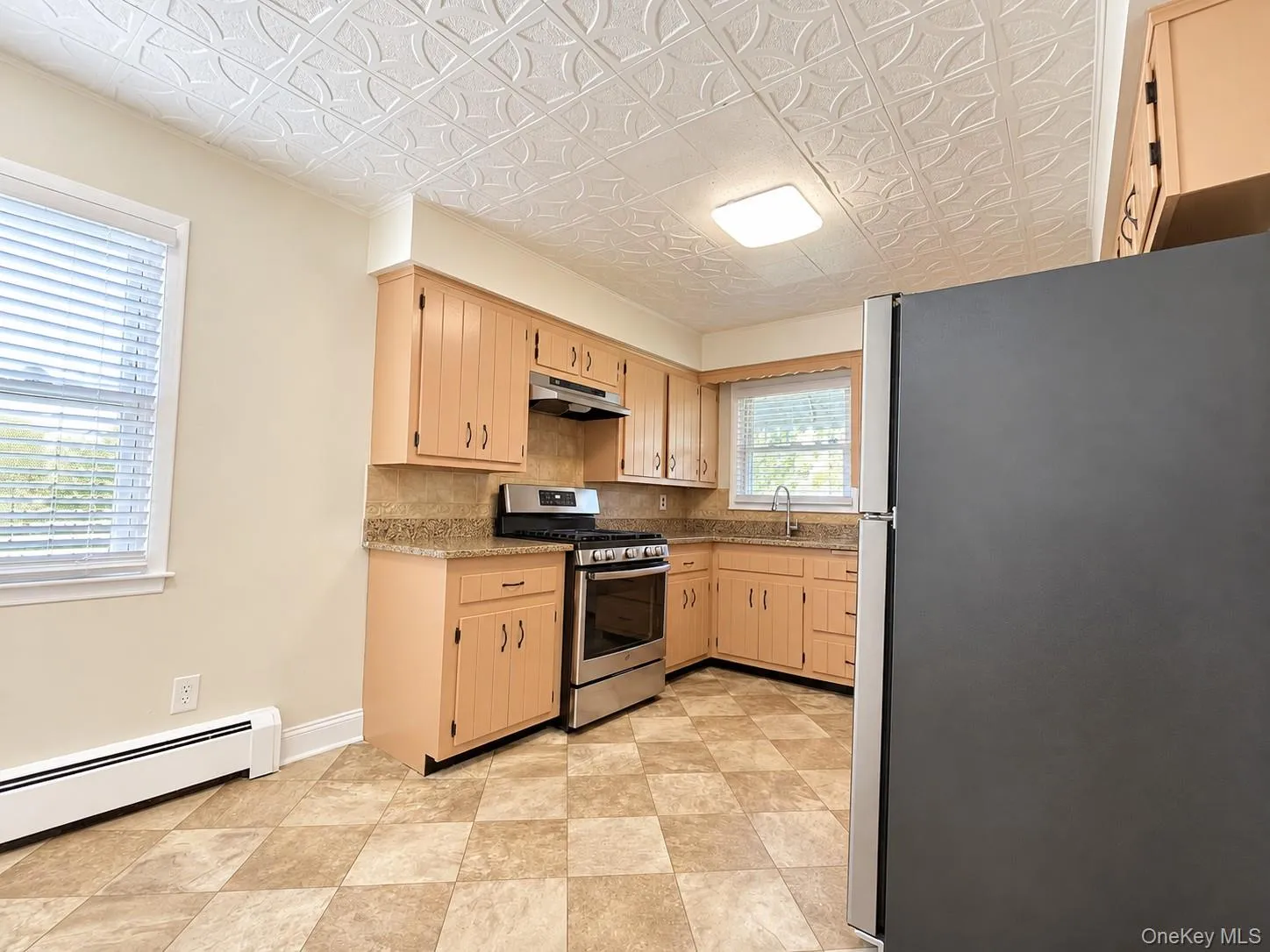 Kitchen featuring wood-finish cabinetry, stainless steel range, and checkerboard floor tiles Kitchen featuring wood-finish cabinetry, stainless steel range, and checkerboard floor tiles