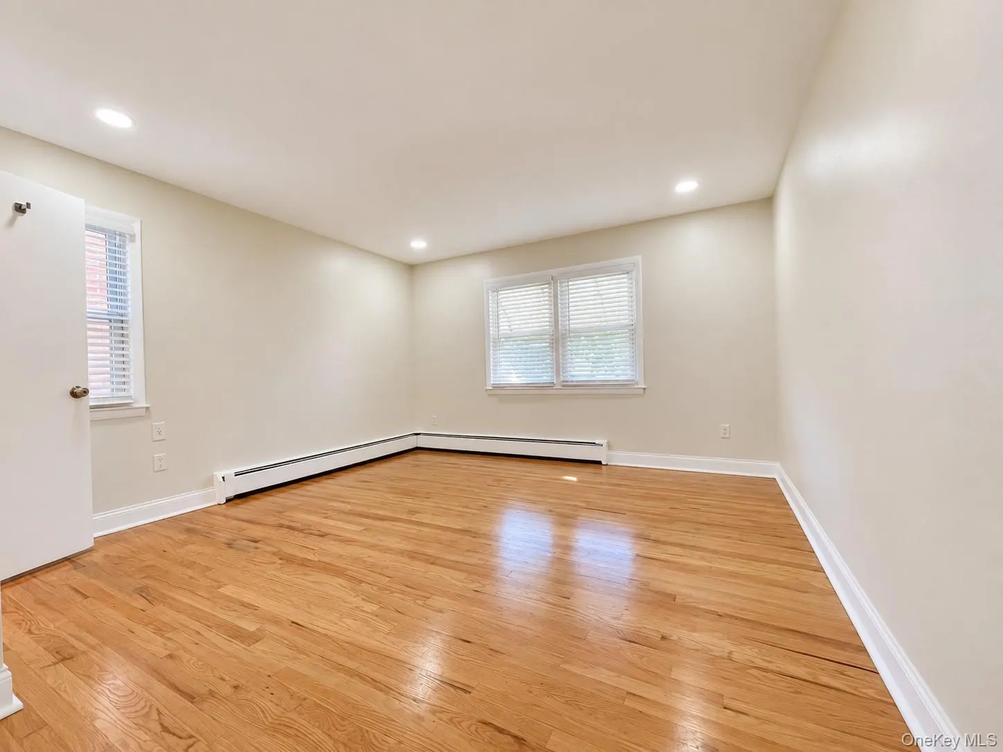 Hardwood flooring complemented by recessed lighting and multiple windows Hardwood flooring complemented by recessed lighting and multiple windows