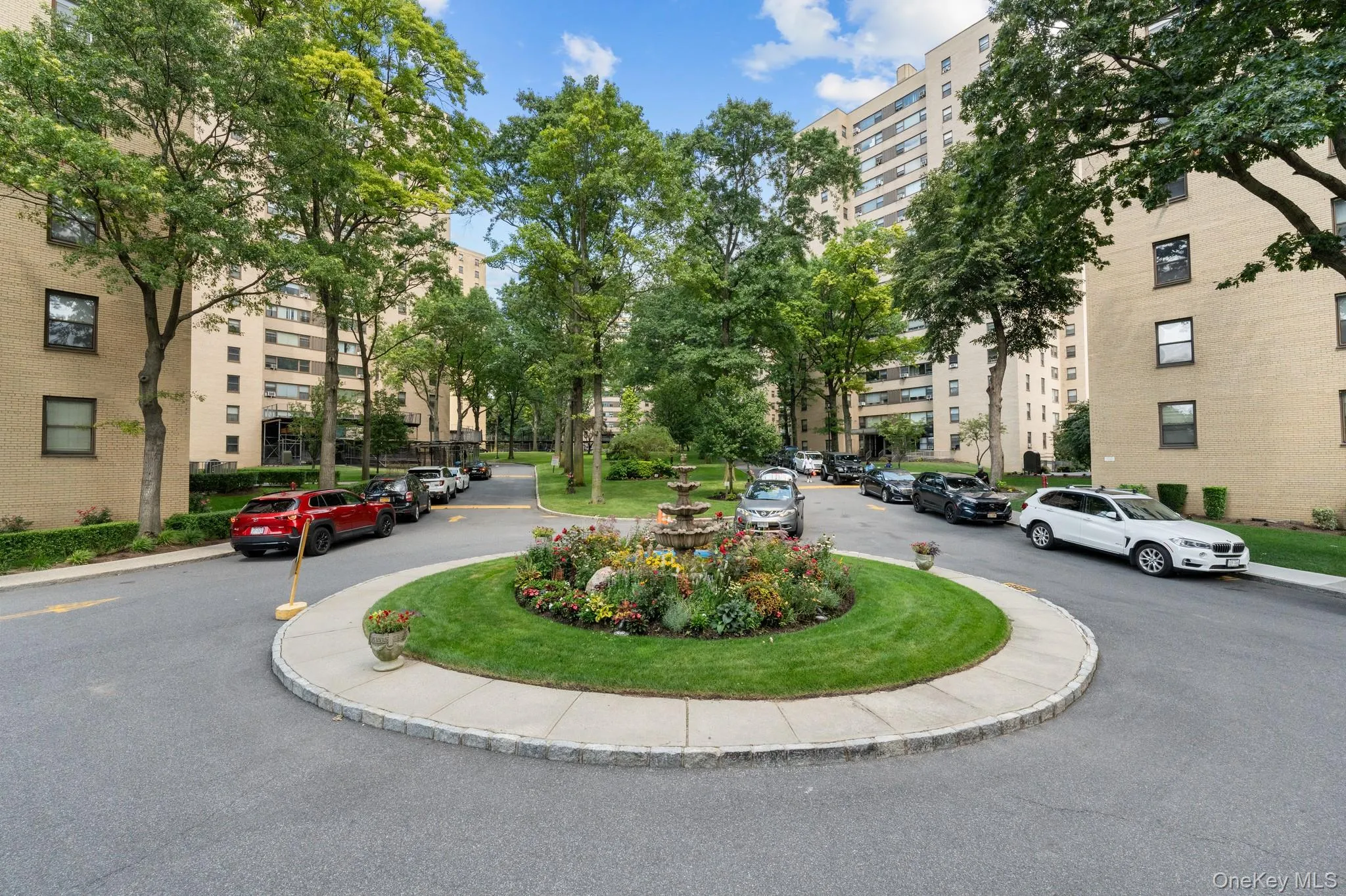 Circular driveway with a central landscaped island featuring a multi-tiered fountain and plantings Circular driveway with a central landscaped island featuring a multi-tiered fountain and plantings