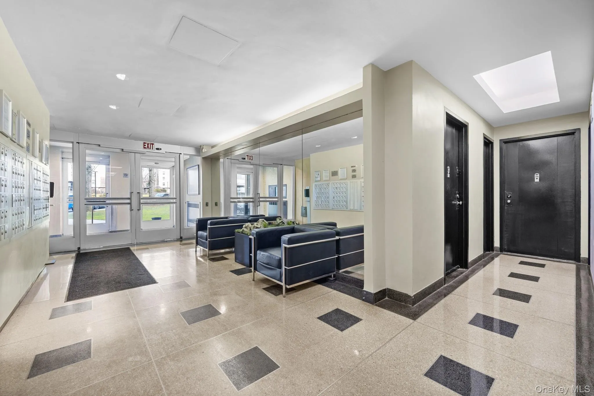Tiled flooring with contrasting inlays, full-height glass doors, mailboxes, recessed lighting, and a skylight Tiled flooring with contrasting inlays, full-height glass doors, mailboxes, recessed lighting, and a skylight