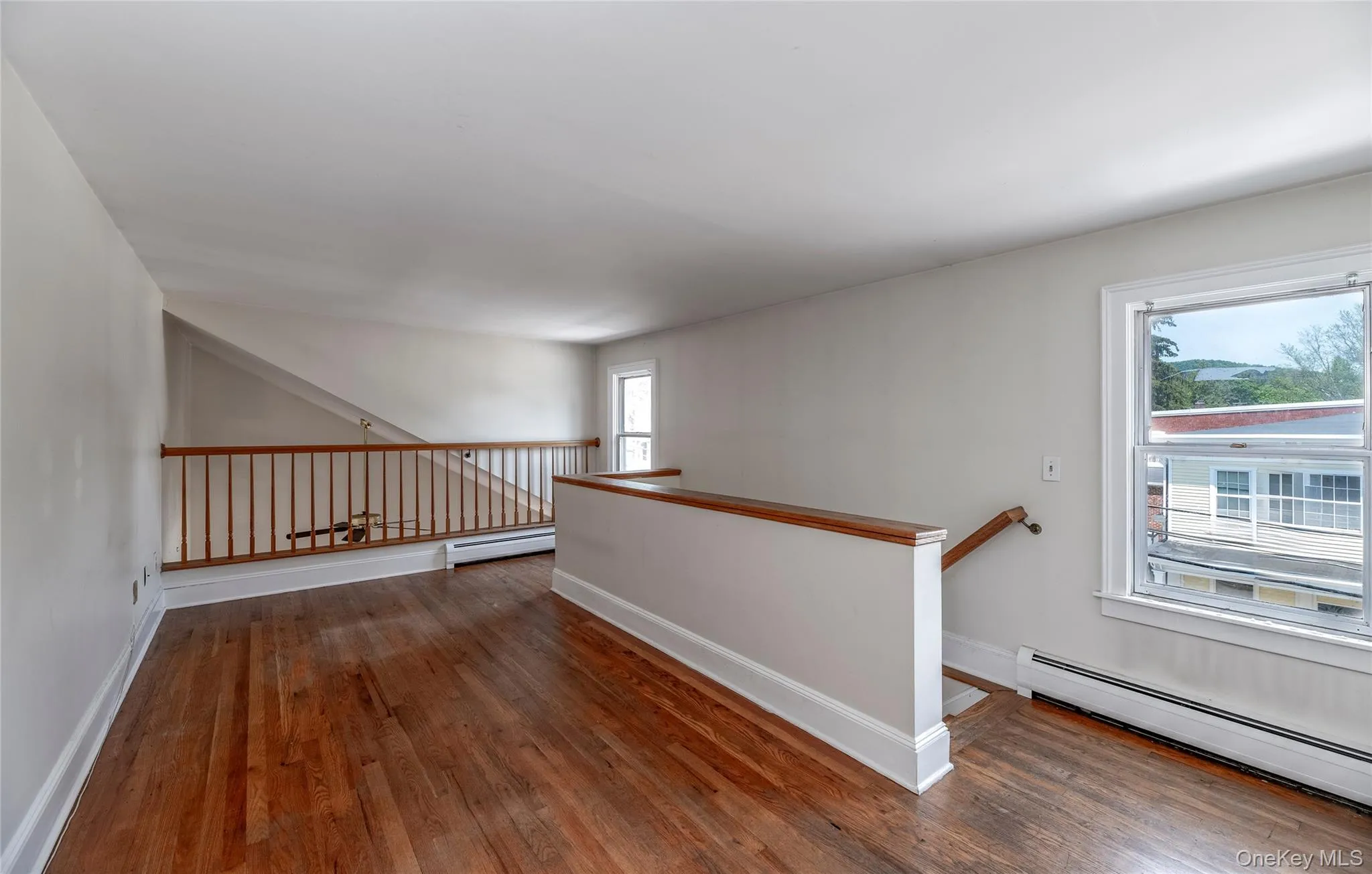 Spare room with a baseboard heating unit and wood finished floors Spare room with a baseboard heating unit and wood finished floors