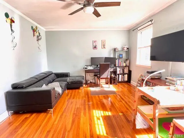 Wood-finish flooring, ceiling fan, crown molding, and window with natural light Wood-finish flooring, ceiling fan, crown molding, and window with natural light