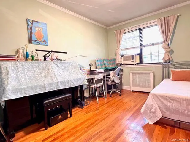 Hardwood flooring throughout, window unit air conditioning, and a built-in radiator cover Hardwood flooring throughout, window unit air conditioning, and a built-in radiator cover