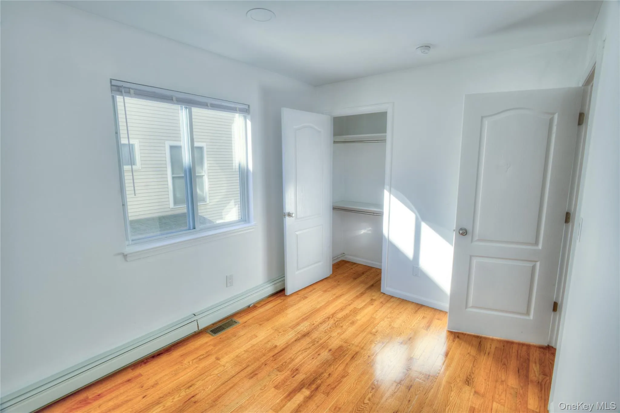 Hardwood flooring, painted walls, white trim, recessed lighting, and a closet with shelving Hardwood flooring, painted walls, white trim, recessed lighting, and a closet with shelving