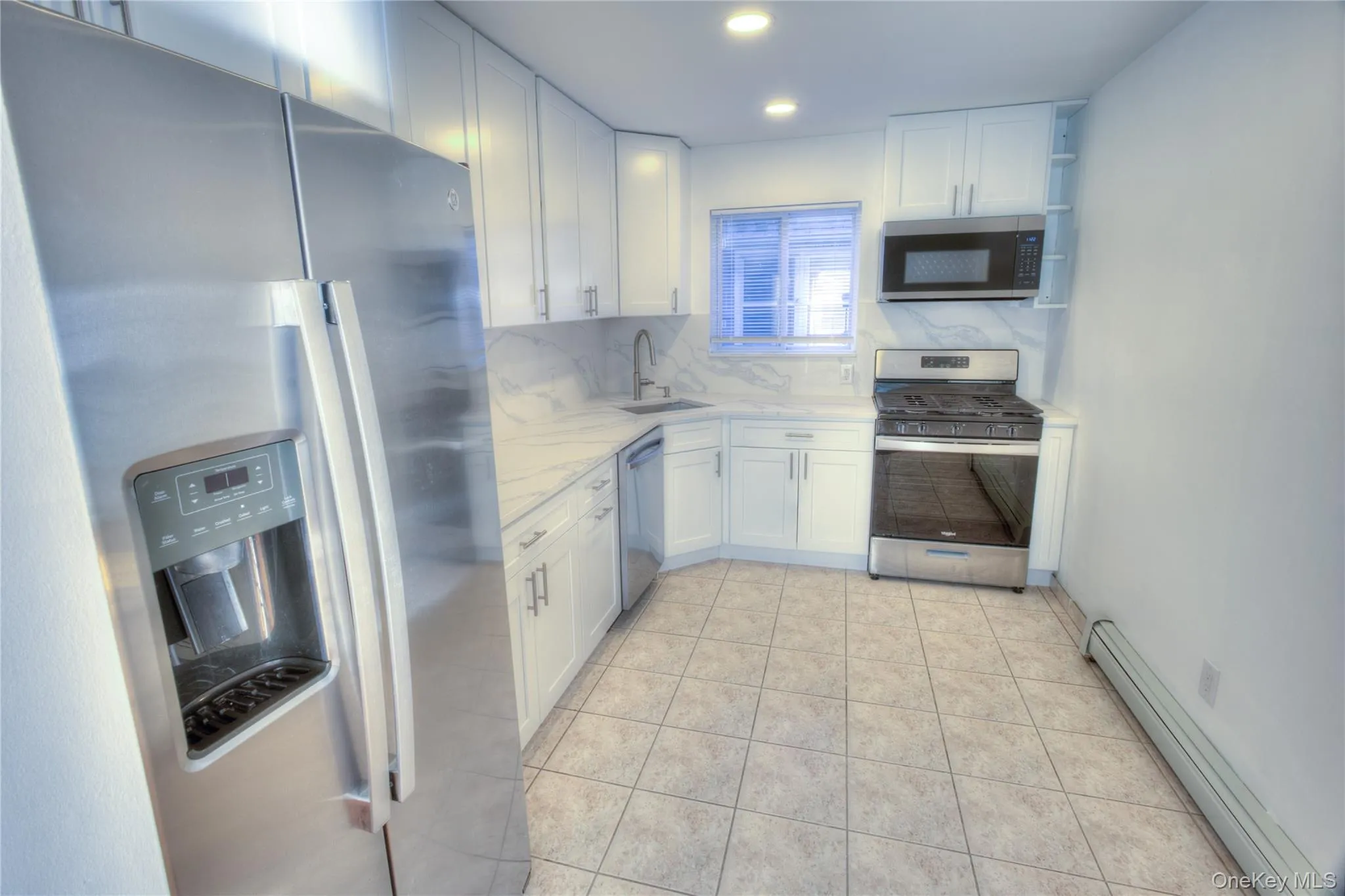 2026 Renovation -Kitchen featuring stainless steel appliances, white cabinetry, a countertop with a subtle veining pattern, ceramic tile flooring, and recessed lighting 2026 Renovation -Kitchen featuring stainless steel appliances, white cabinetry, a countertop with a subtle veining pattern, ceramic tile flooring, and recessed lighting