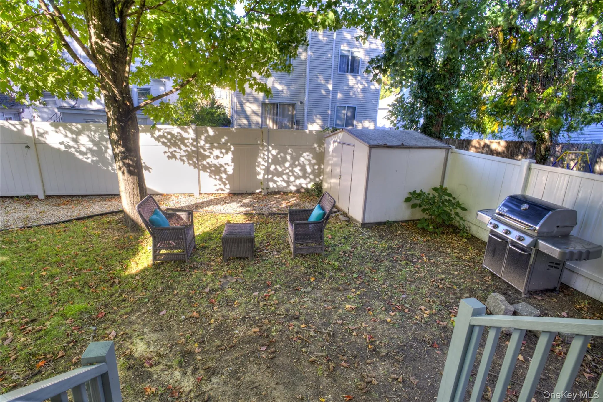 Fenced backyard with a storage shed and mature trees Fenced backyard with a storage shed and mature trees