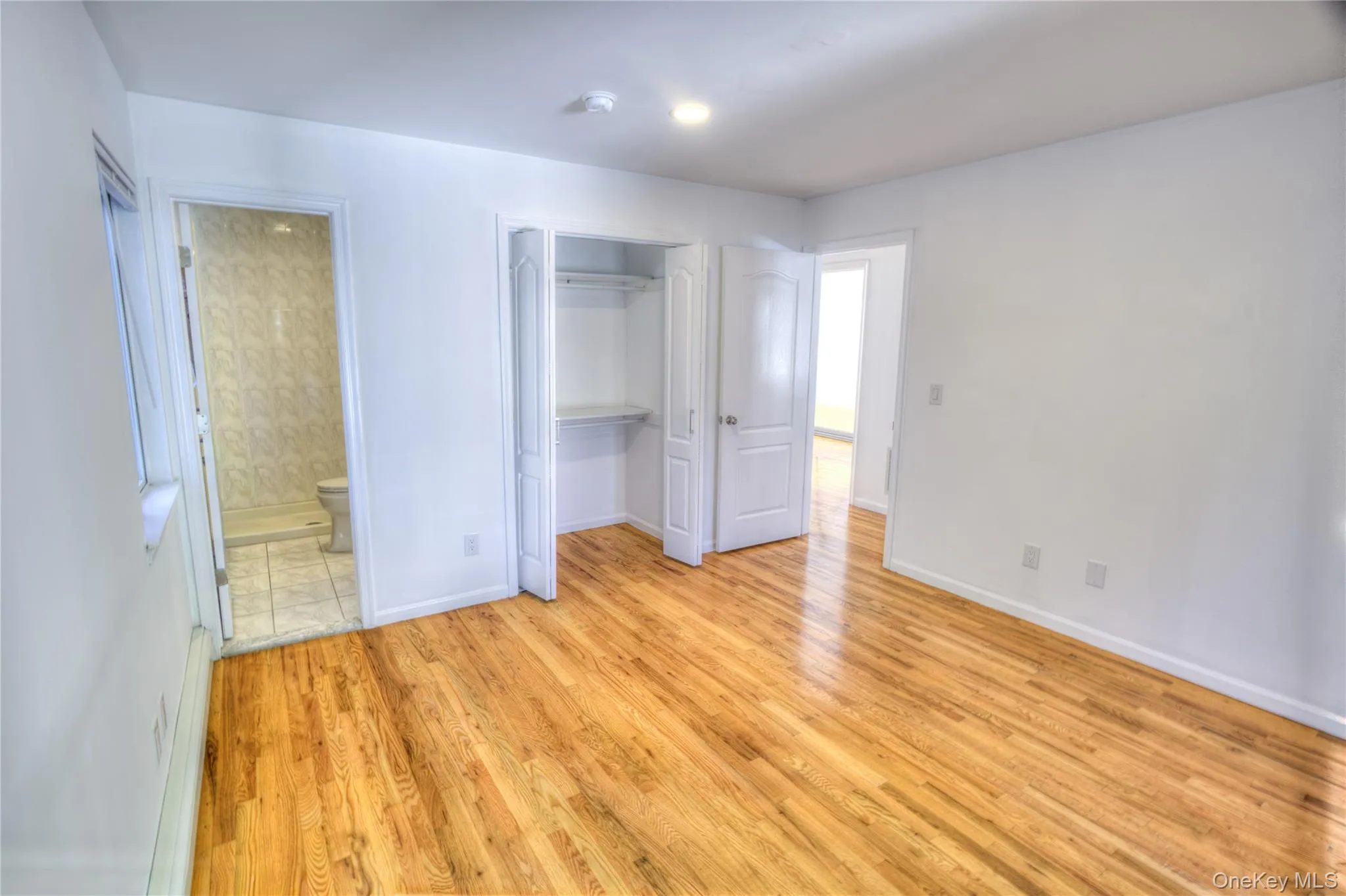Renovated 2026 Hardwood flooring throughout, white walls, built-in closet with shelves, and recessed lighting Renovated 2026 Hardwood flooring throughout, white walls, built-in closet with shelves, and recessed lighting